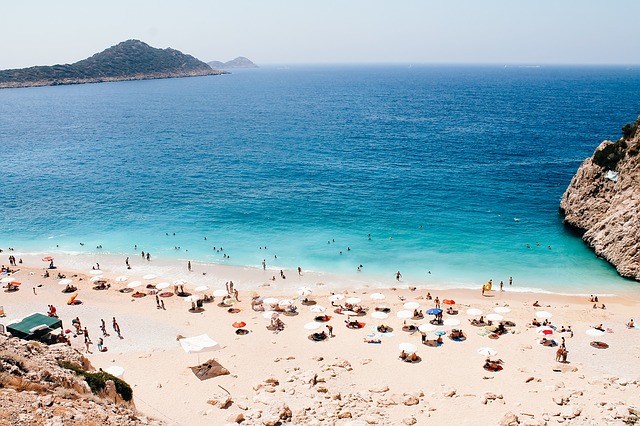 Piesočnatá pláž s množstvom turistov v Turecku
